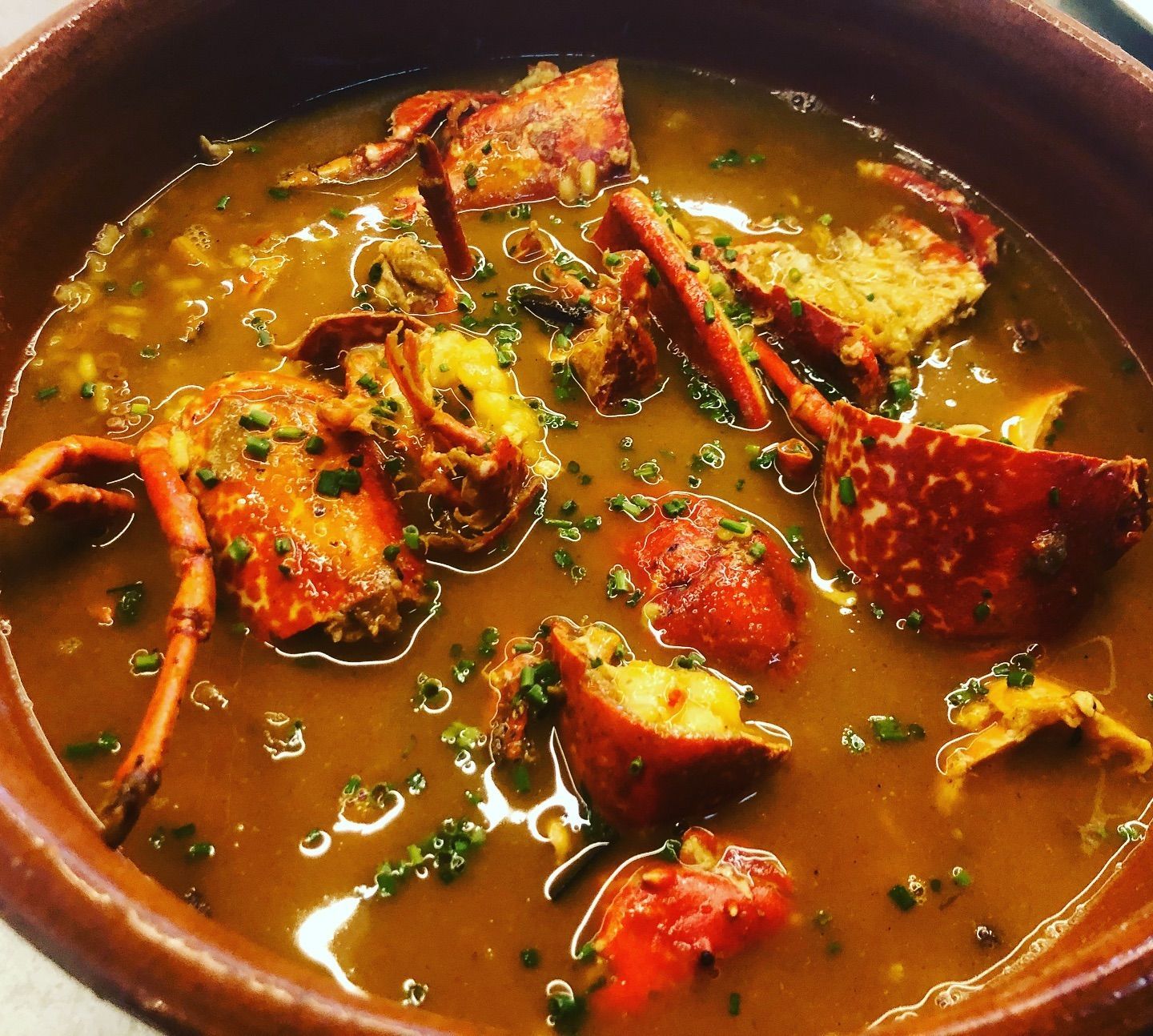 Un primer plano de un tazón de sopa con langostas.