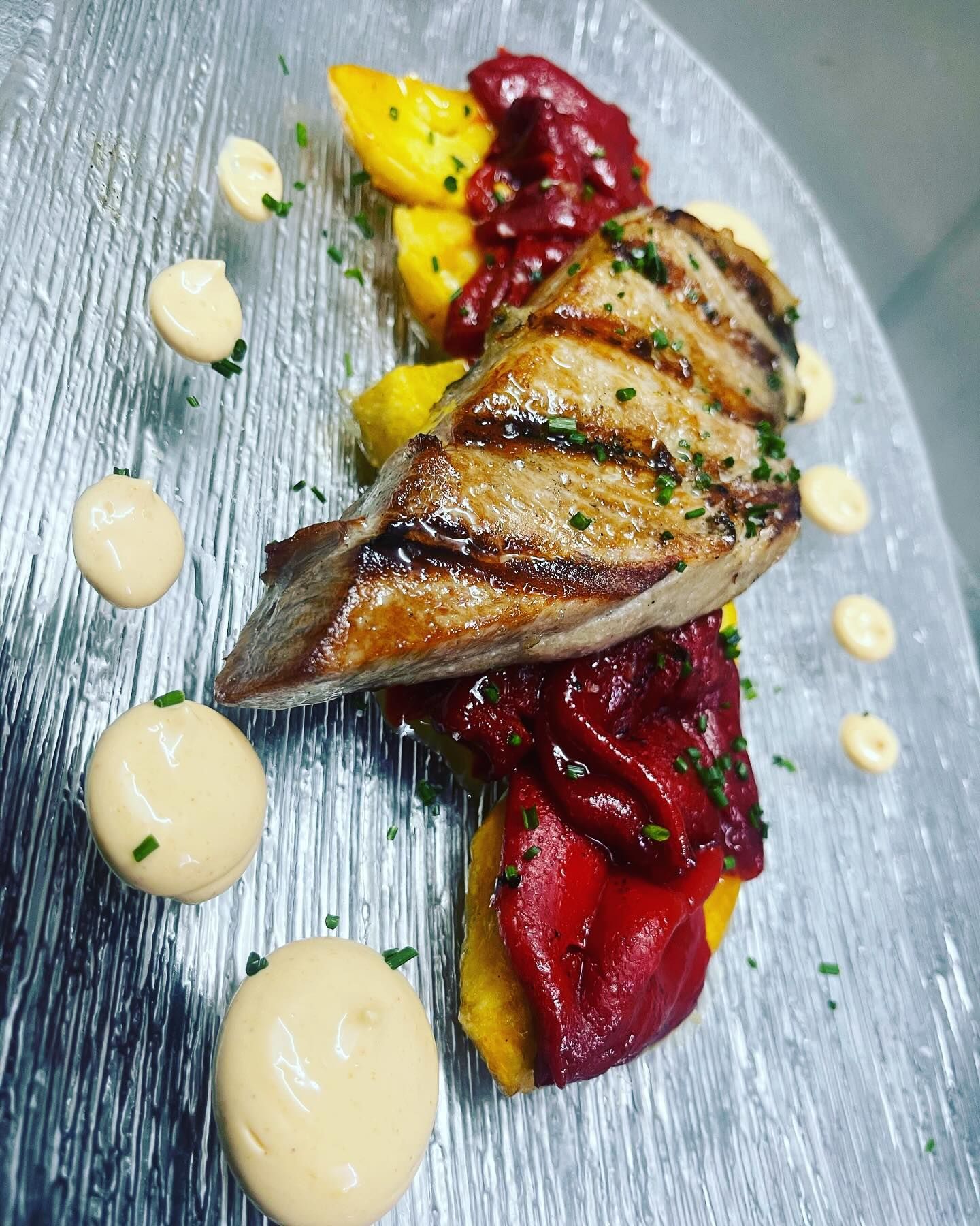 Un plato de comida con carne y verduras encima.