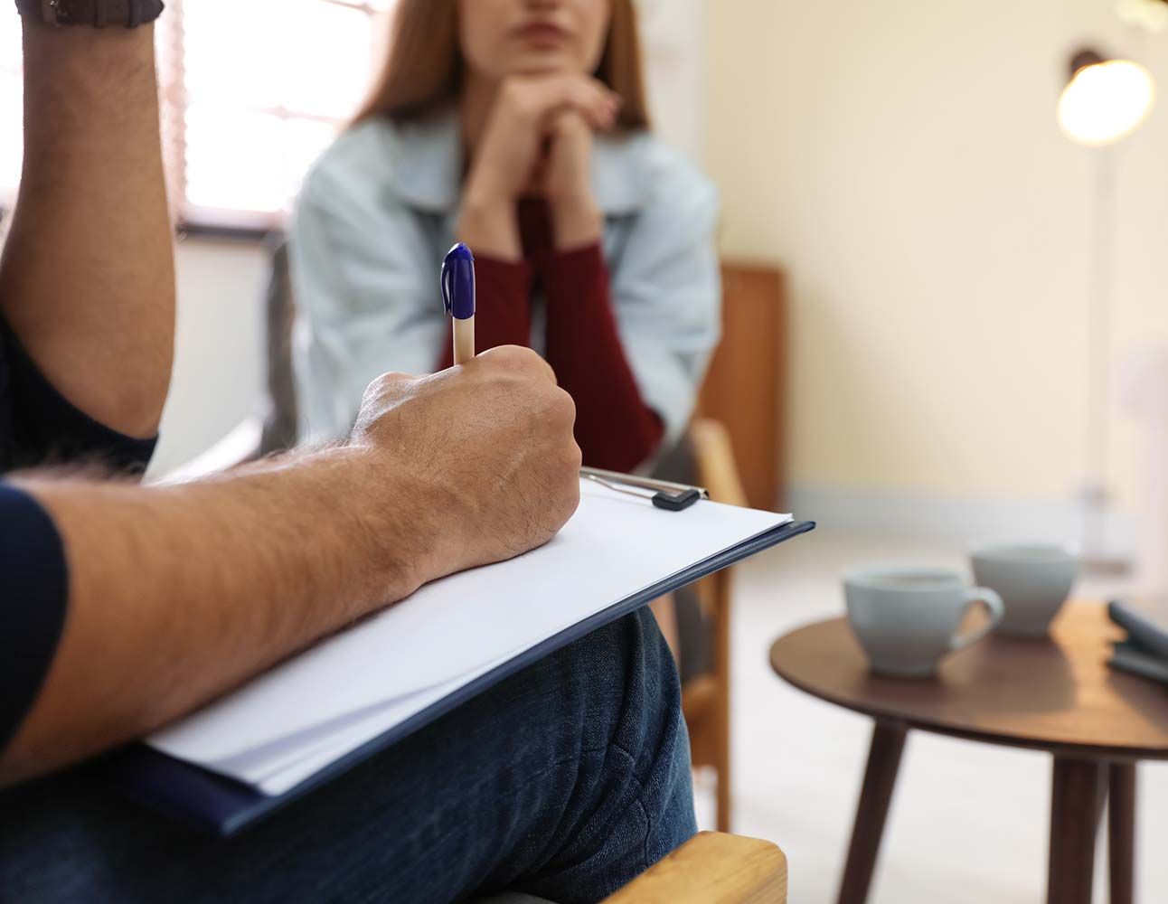 Un hombre está escribiendo en un portapapeles mientras habla con una mujer.