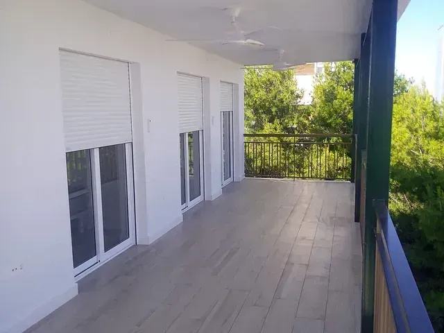 Un balcón con muchas ventanas y un ventilador de techo.