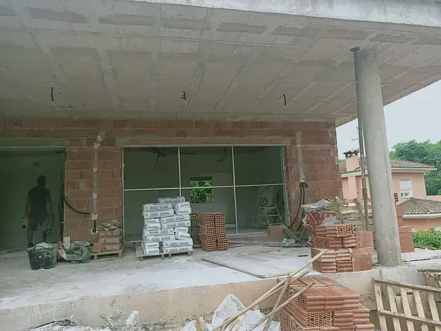 Un edificio en construcción con muchos ladrillos en el suelo.