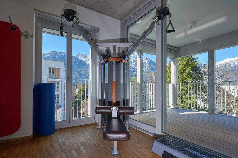 Ein Fitnessstudio mit Laufband und Bank.