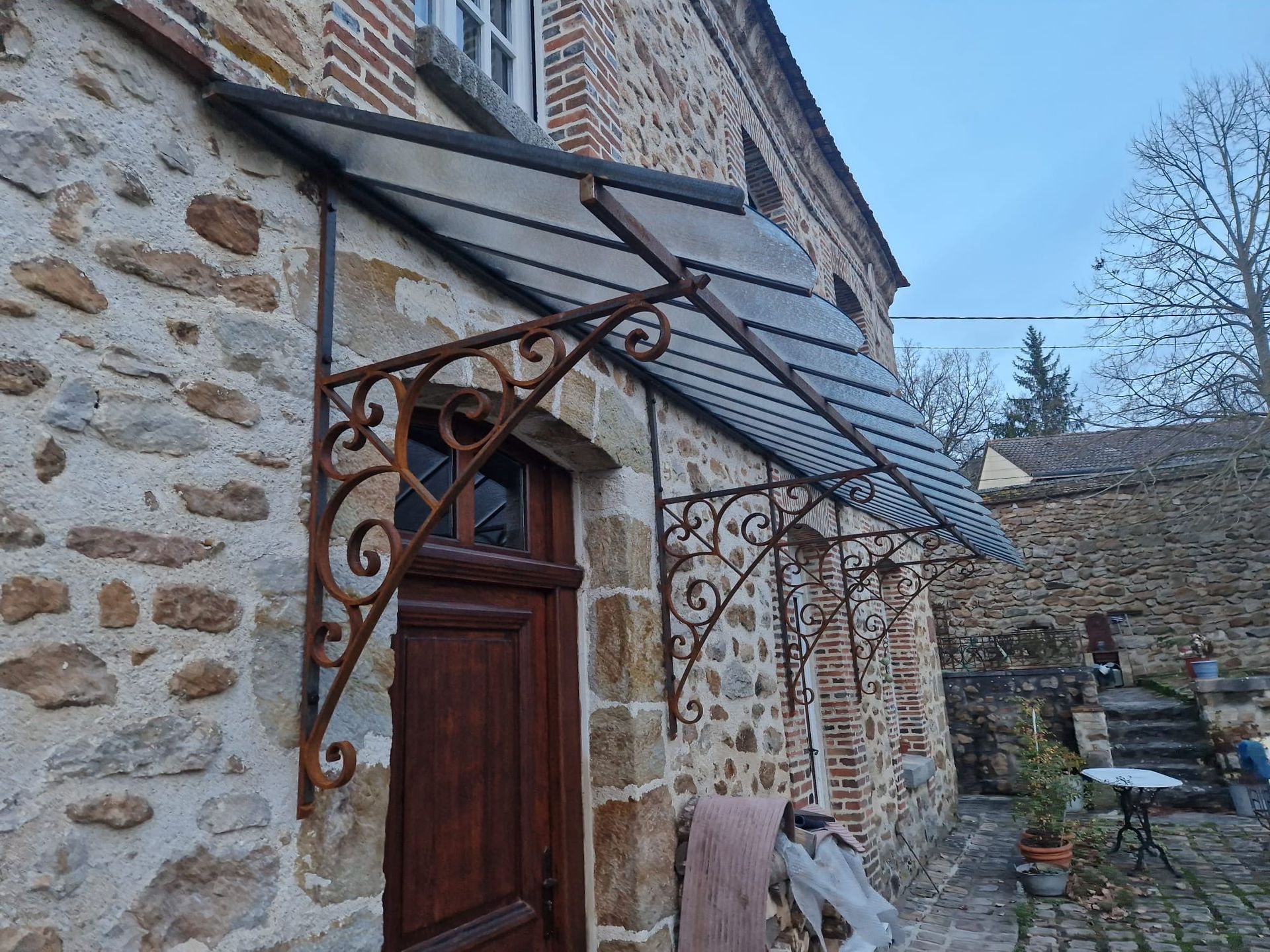 Ouvrier installant une porte coulissante en verre noir dans une pièce moderne.