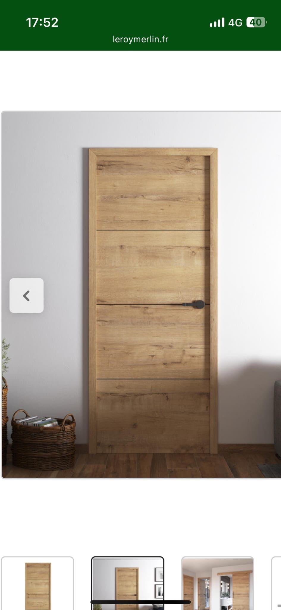 Porte en bois à panneaux verticaux et poignée foncée sur un mur blanc.