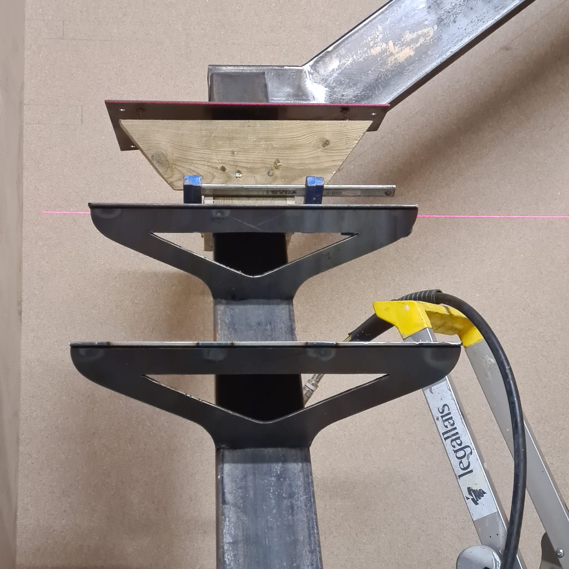 Ensemble de support métallique avec deux étagères noires sur un poteau vertical  avec un tuyau.