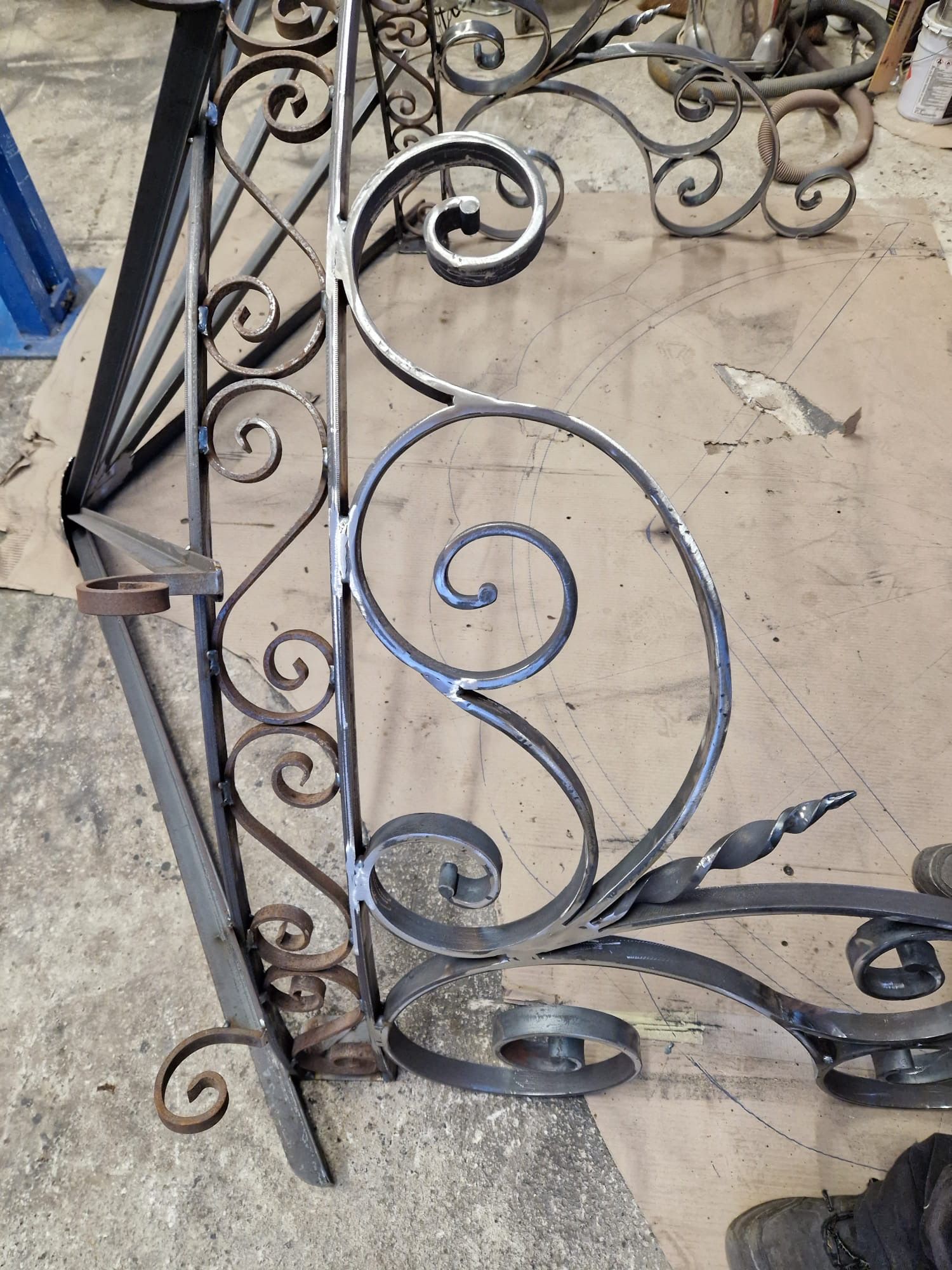 Portail ou balustrade décorative en fer forgé noir à volutes.