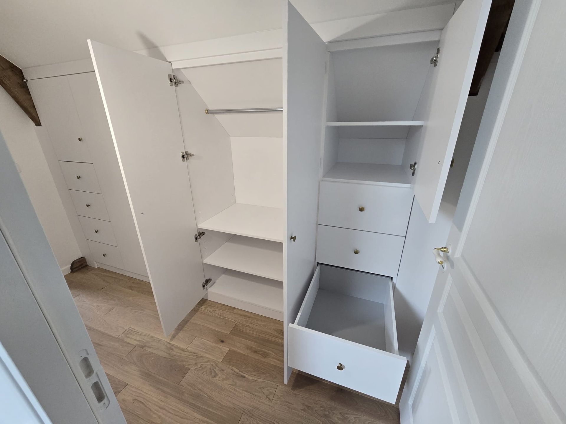 Ouvrier installant une porte coulissante en verre dans un intérieur de maison moderne.