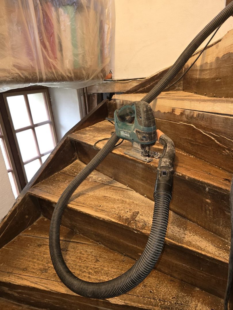 Ouvrier installant une porte coulissante en verre dans un intérieur de maison moderne.