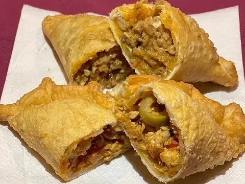 Un primer plano de cuatro pasteles en una servilleta sobre una mesa.