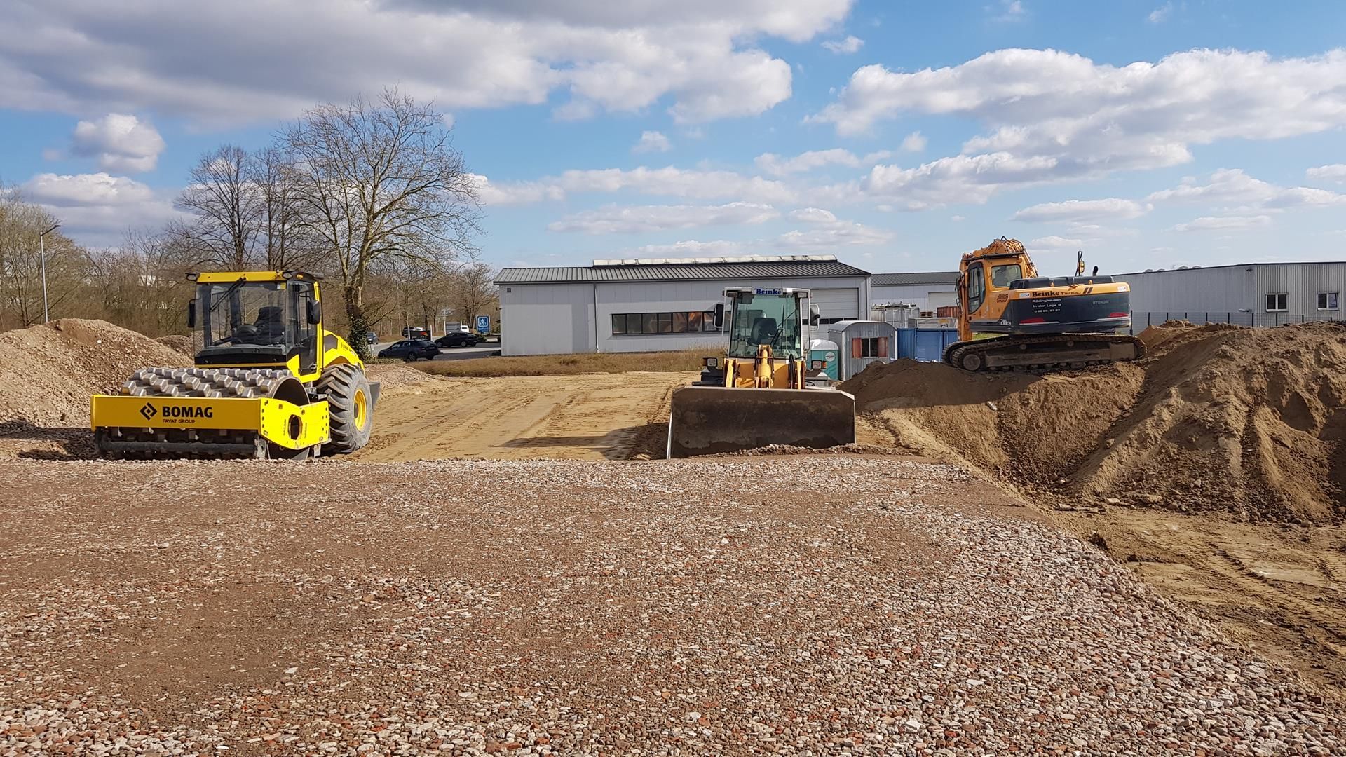 Eine Gruppe von Baufahrzeugen arbeitet auf einem Feld.