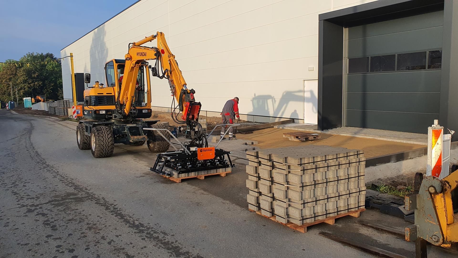 Ein gelber Bagger steht vor einem Gebäude.