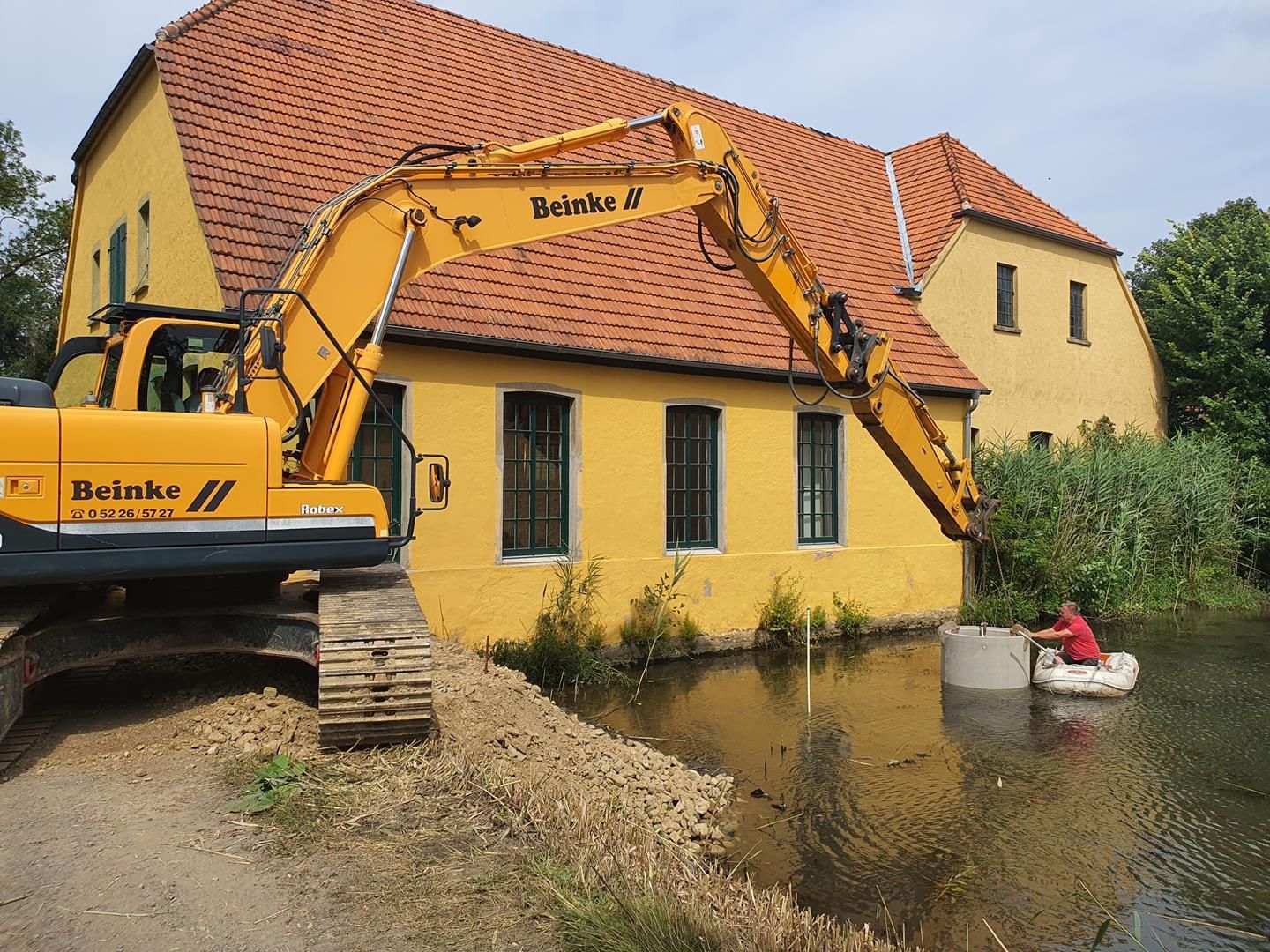 Ein gelber Bagger parkt vor einem gelben Gebäude