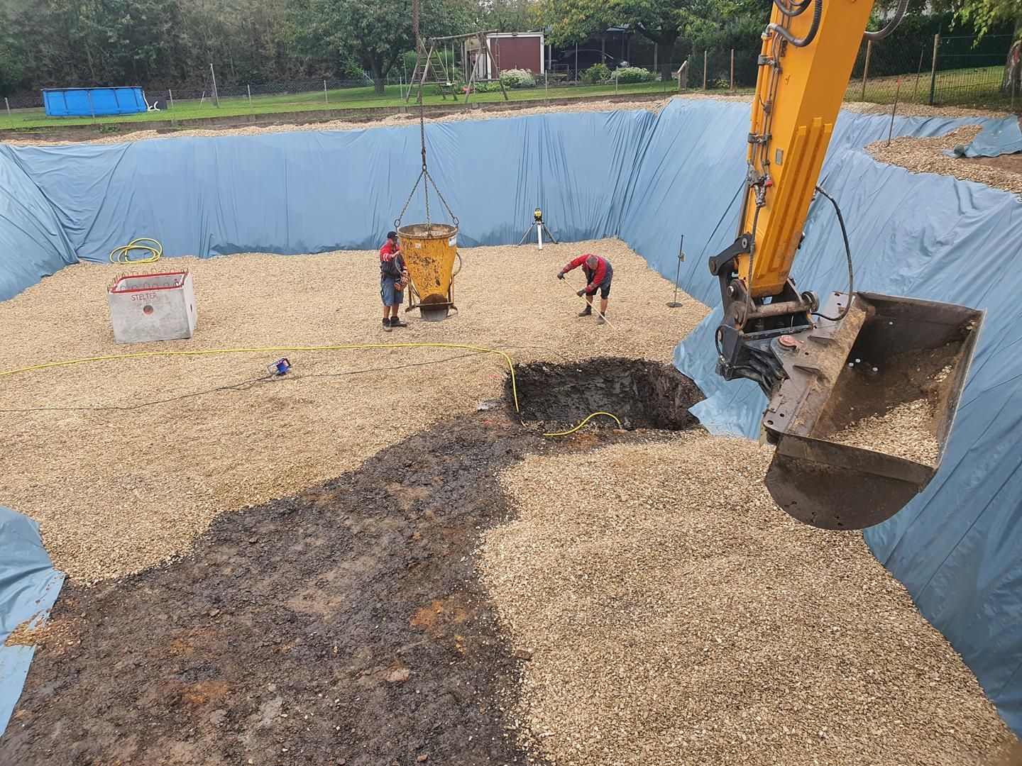 Ein großer gelber Bagger gräbt ein Loch in den Boden.