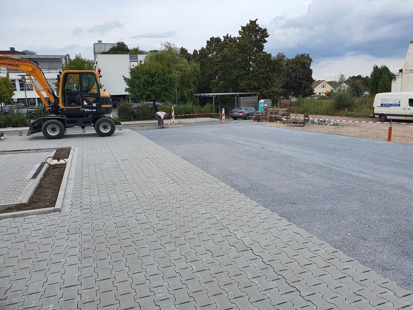 Ein gelber Bagger steht auf einem Parkplatz