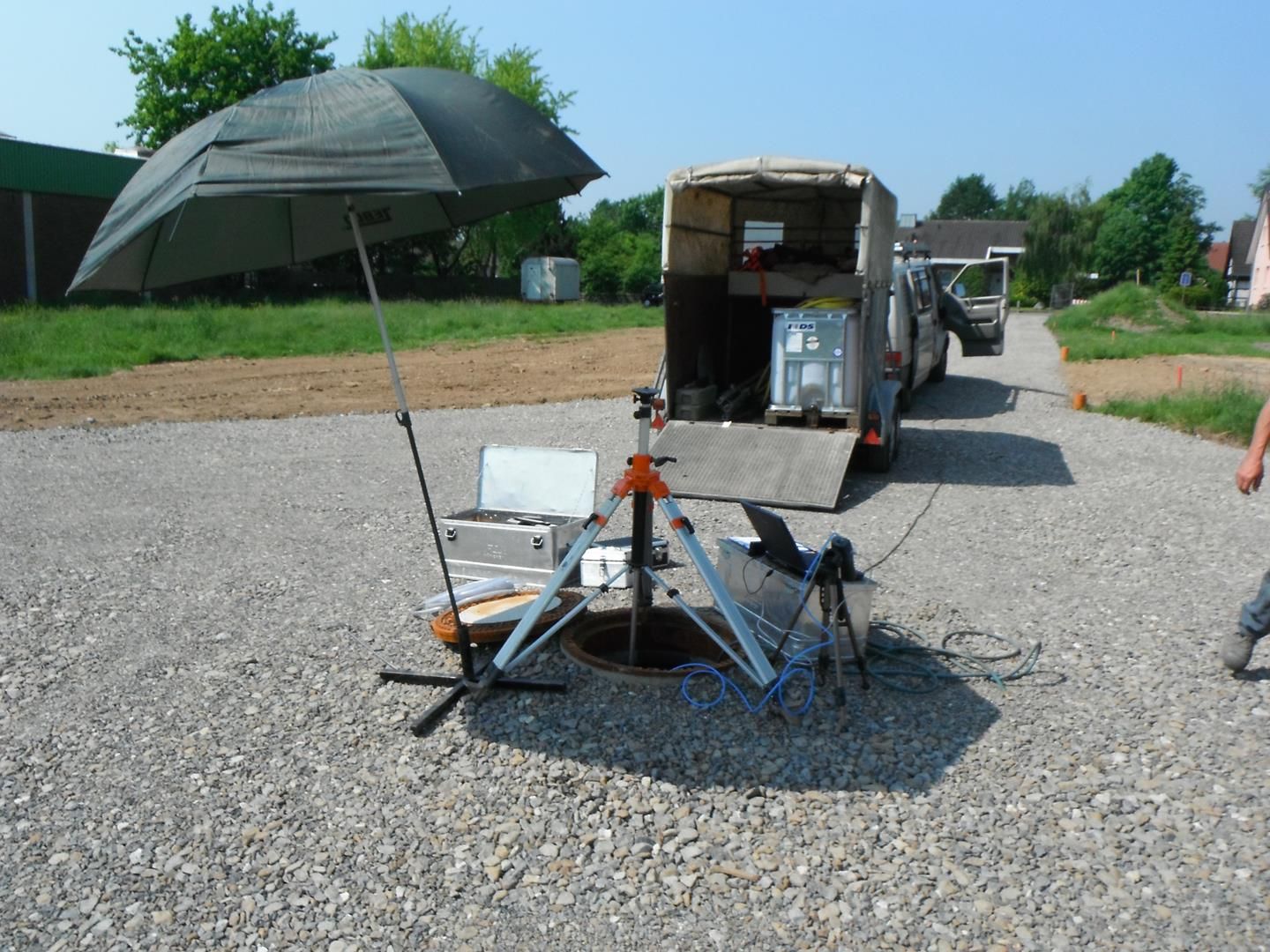 Ein Lieferwagen parkt in einer Kiesauffahrt neben einem Regenschirm
