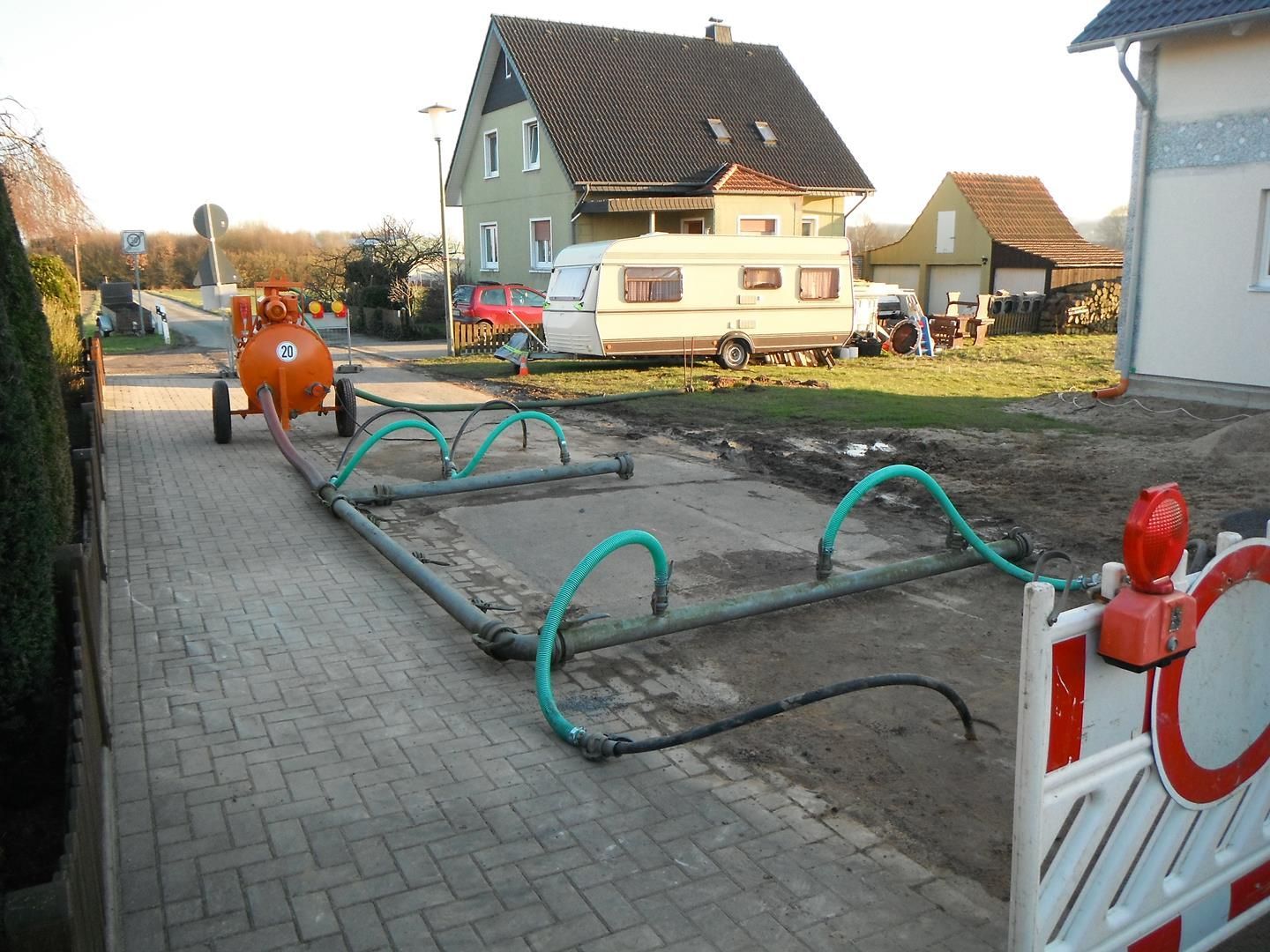 Ein weißer Wohnwagen parkt vor einem Haus
