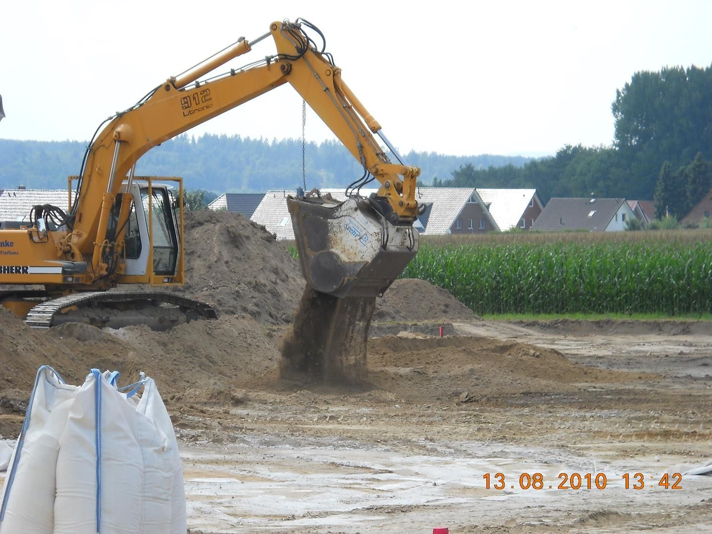Ein gelber Bagger gräbt in einem Erdfeld