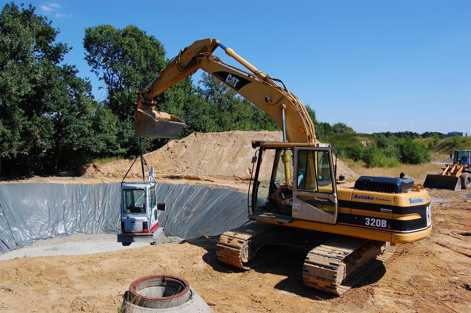 Ein Katzenbagger gräbt ein Loch in den Dreck