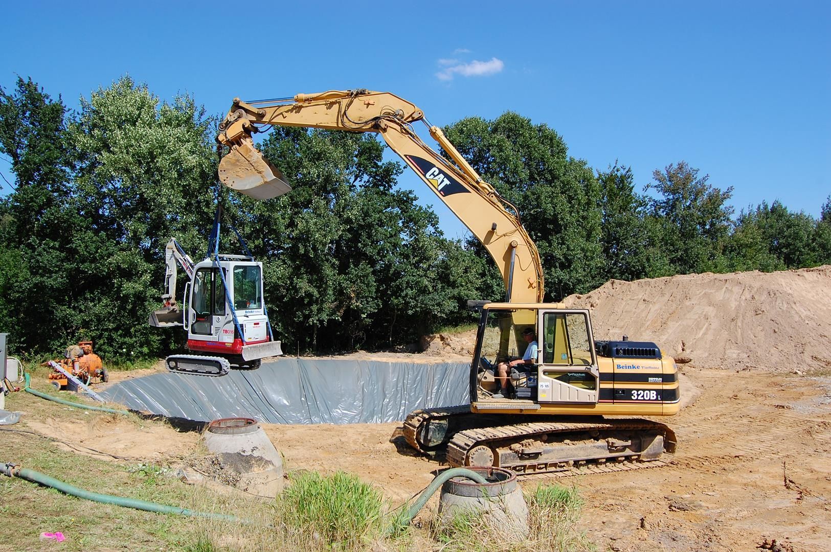 Ein großer gelber Bagger gräbt in einem Erdfeld