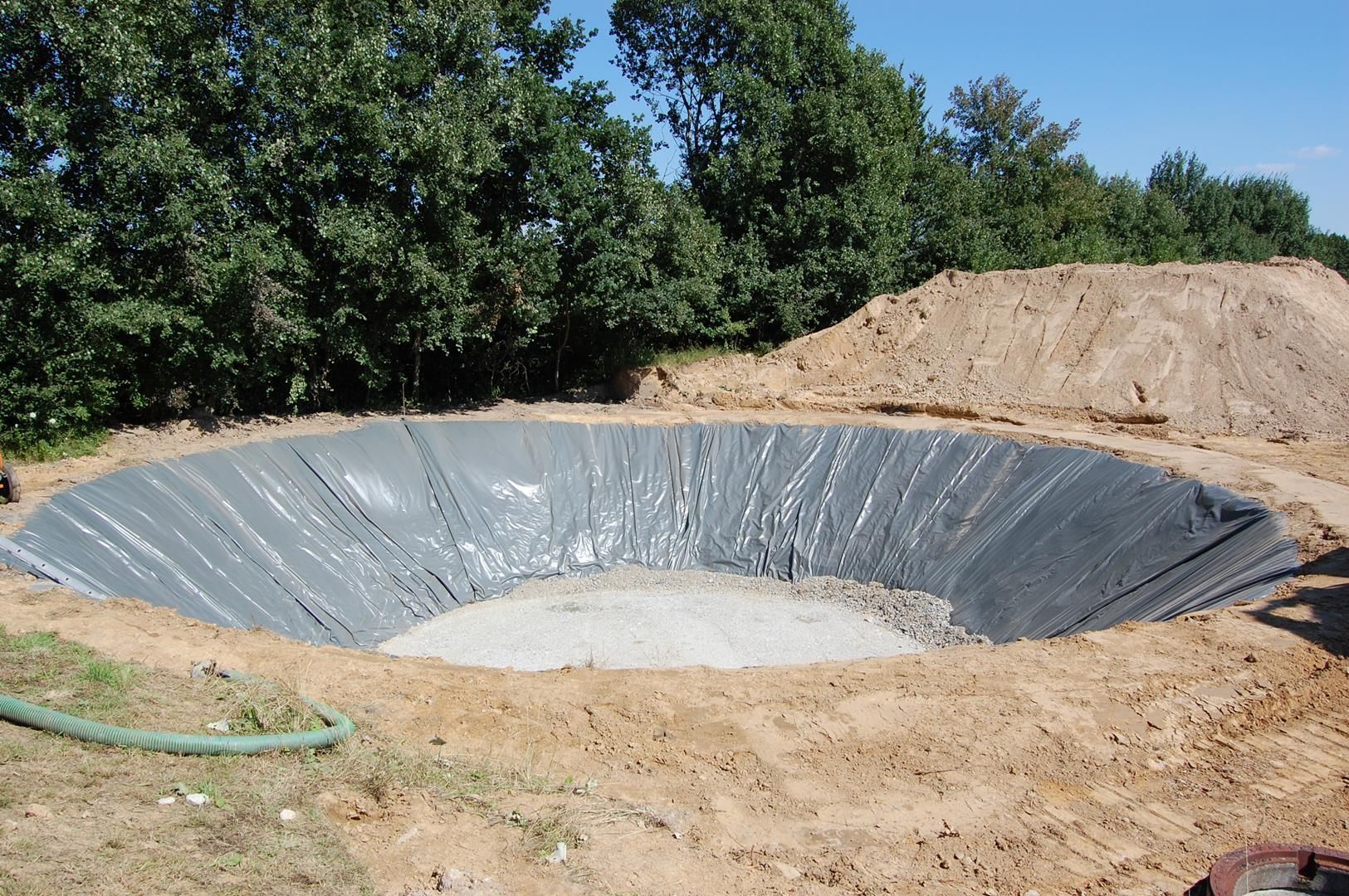 ein großes rundes Loch in der Mitte eines Feldes mit Bäumen im Hintergrund