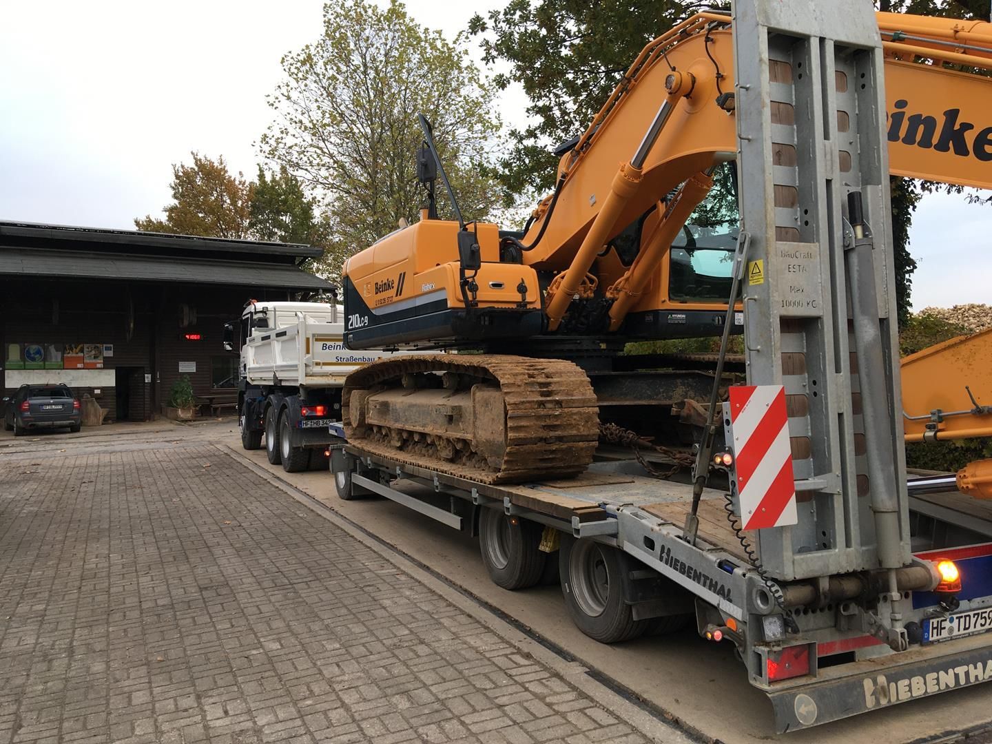 Ein gelber Bagger sitzt auf einem Tieflader.