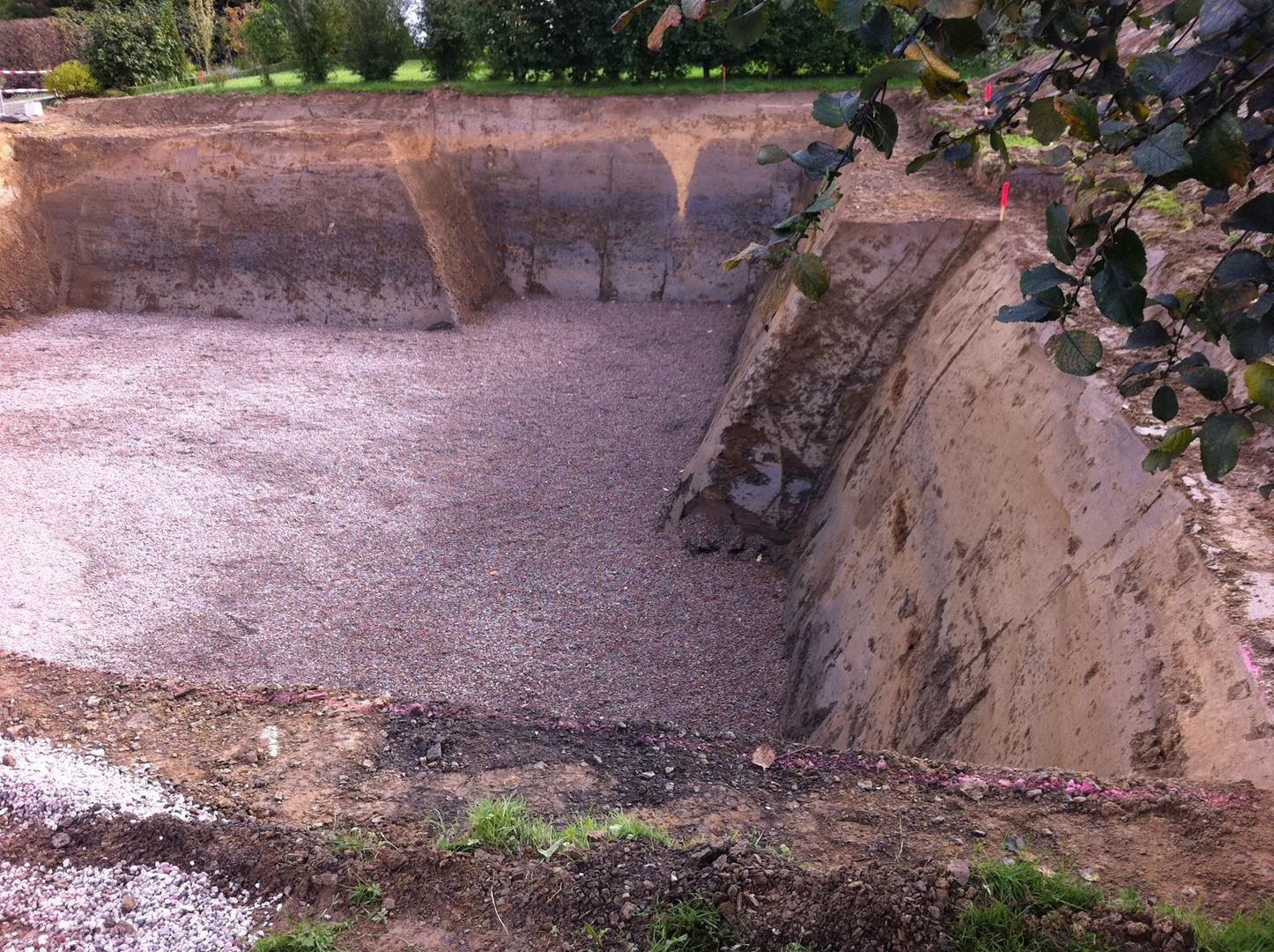 Ein großer Haufen Erde und Kies liegt mitten auf einem Feld.
