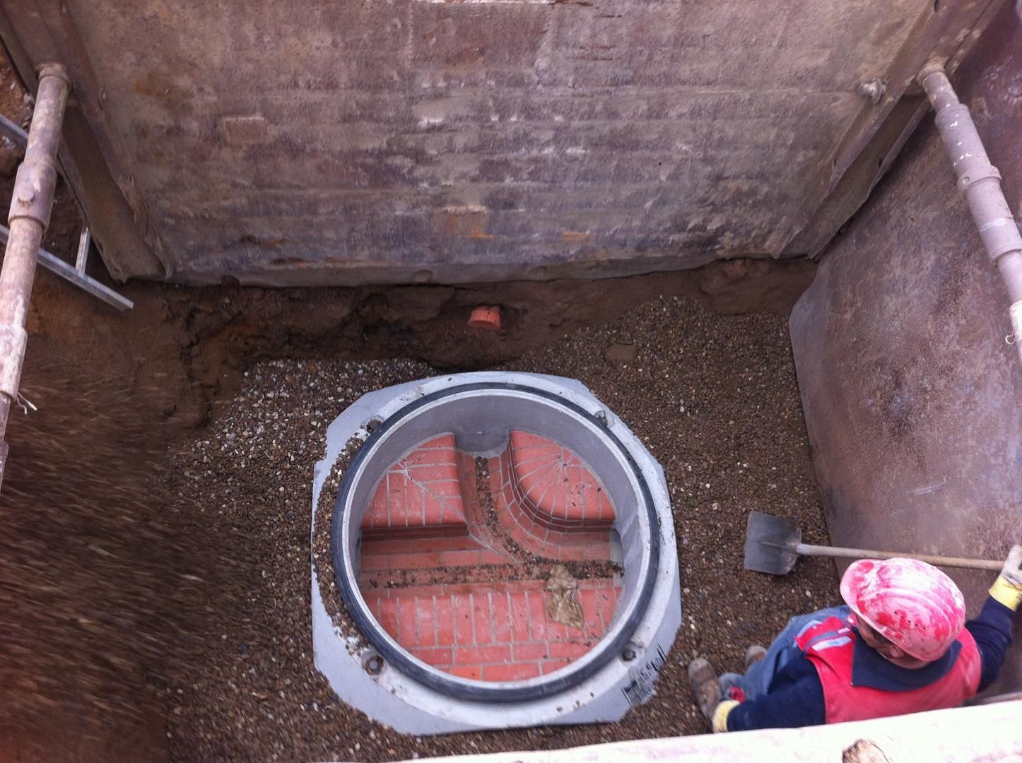 Ein Mann mit Schutzhelm arbeitet in einem Loch