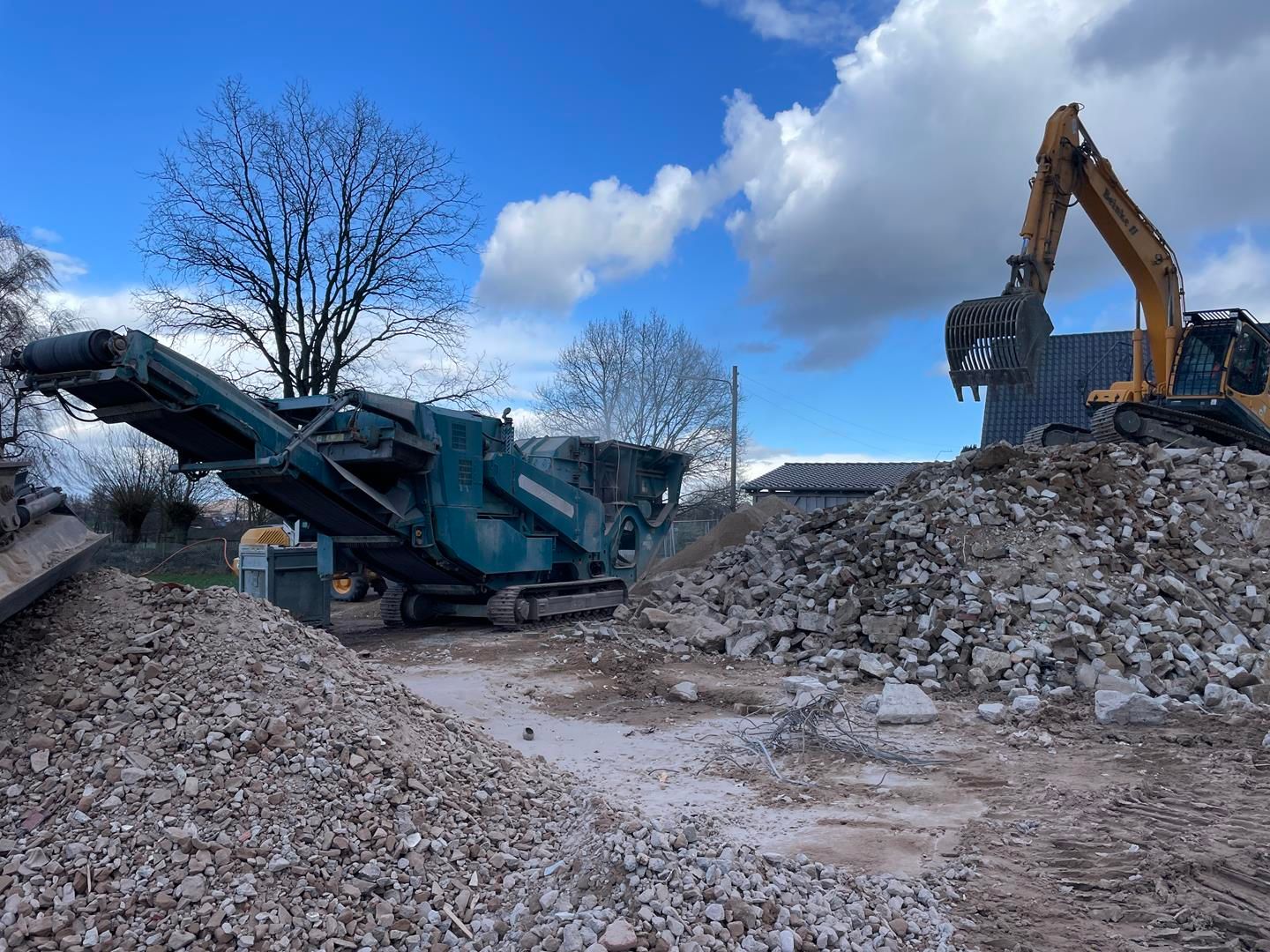 Ein großer Steinhaufen wird von einer Maschine bearbeitet.