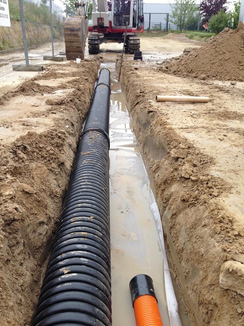 In einem Graben wird ein großes Rohr verlegt.