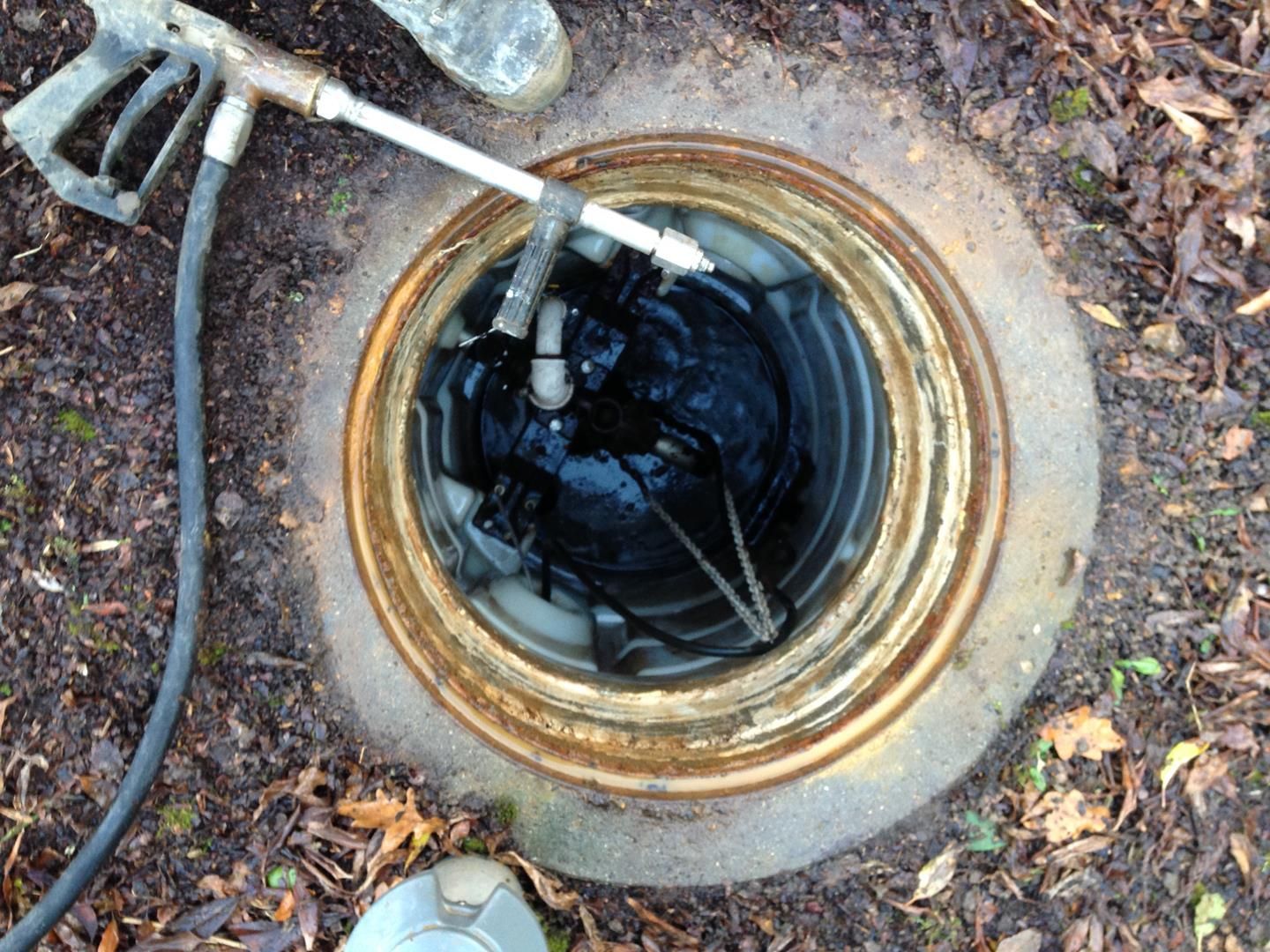 ein Schachtdeckel mit daran befestigtem Schlauch