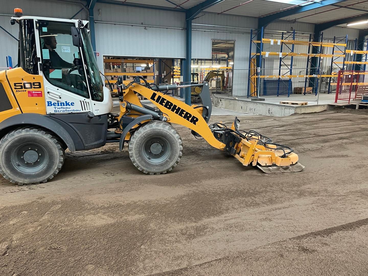 Ein gelber Liebherr-Traktor steht in einer Lagerhalle.