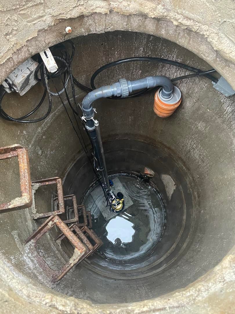 ein Schacht mit einer Pumpe in der Mitte.