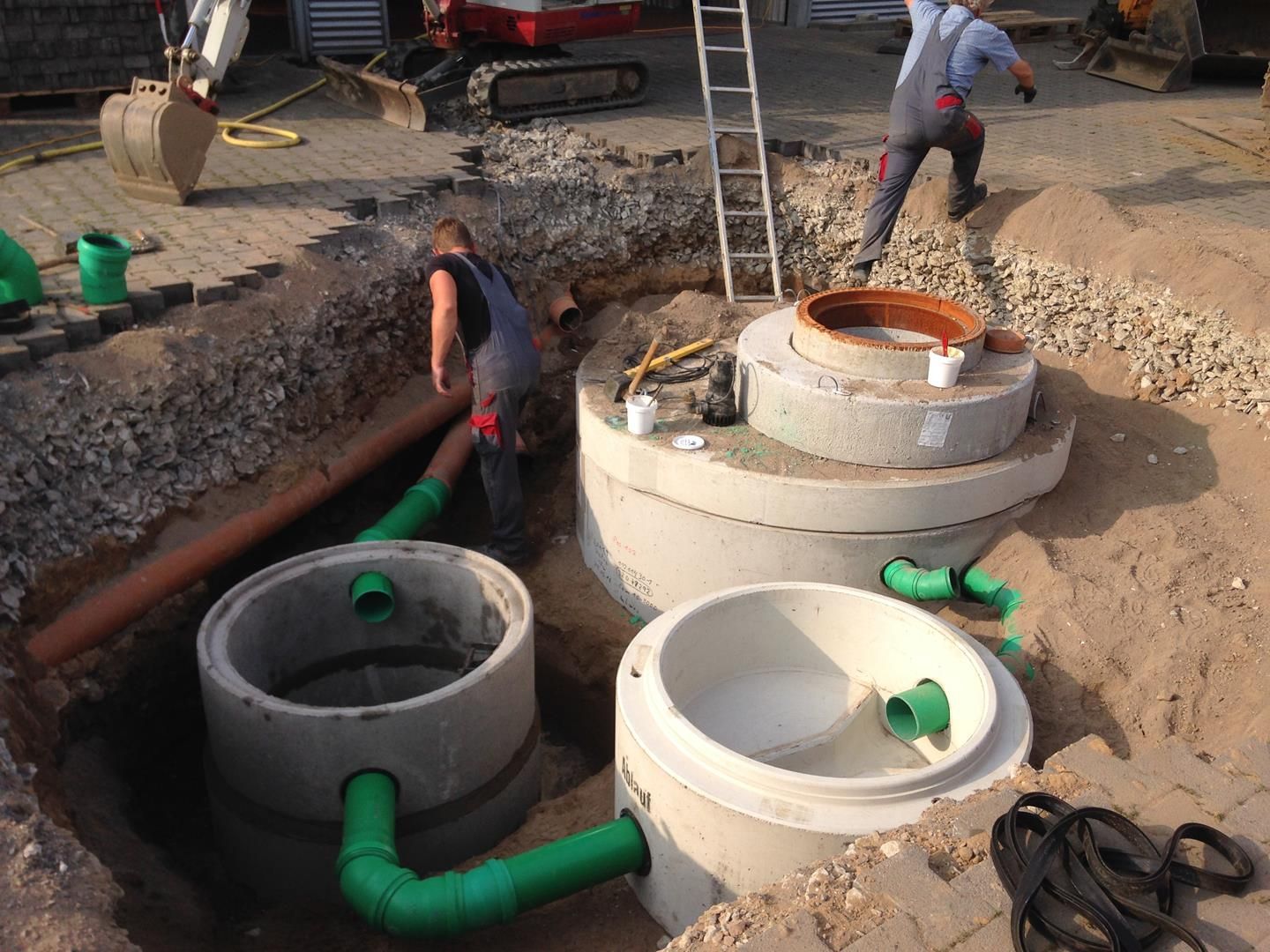 Ein Mann arbeitet an einem Betonring im Dreck.