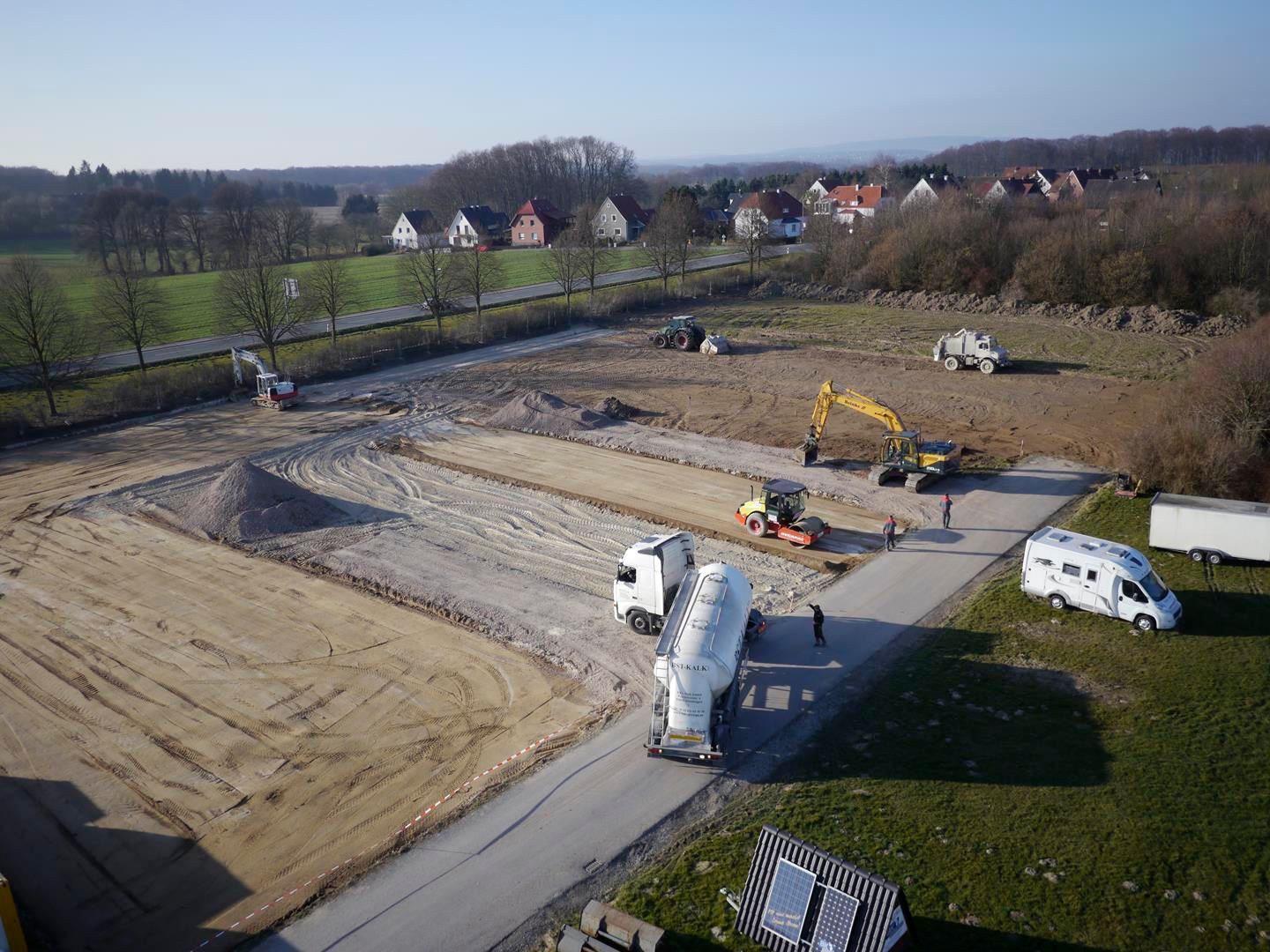 eine Luftaufnahme einer Baustelle mit Lastkraftwagen und Traktoren