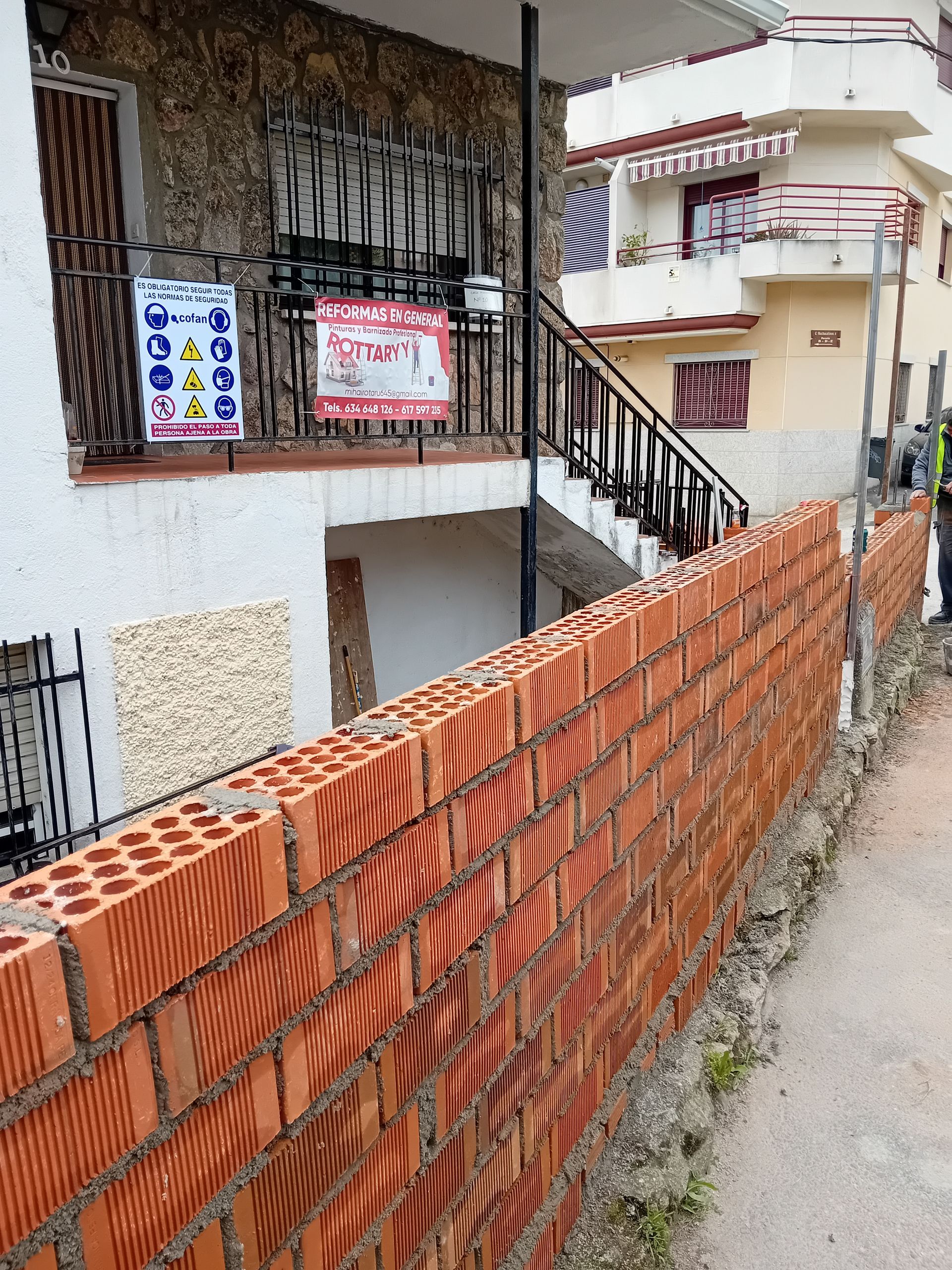 Se está construyendo un muro de ladrillos frente a un edificio.