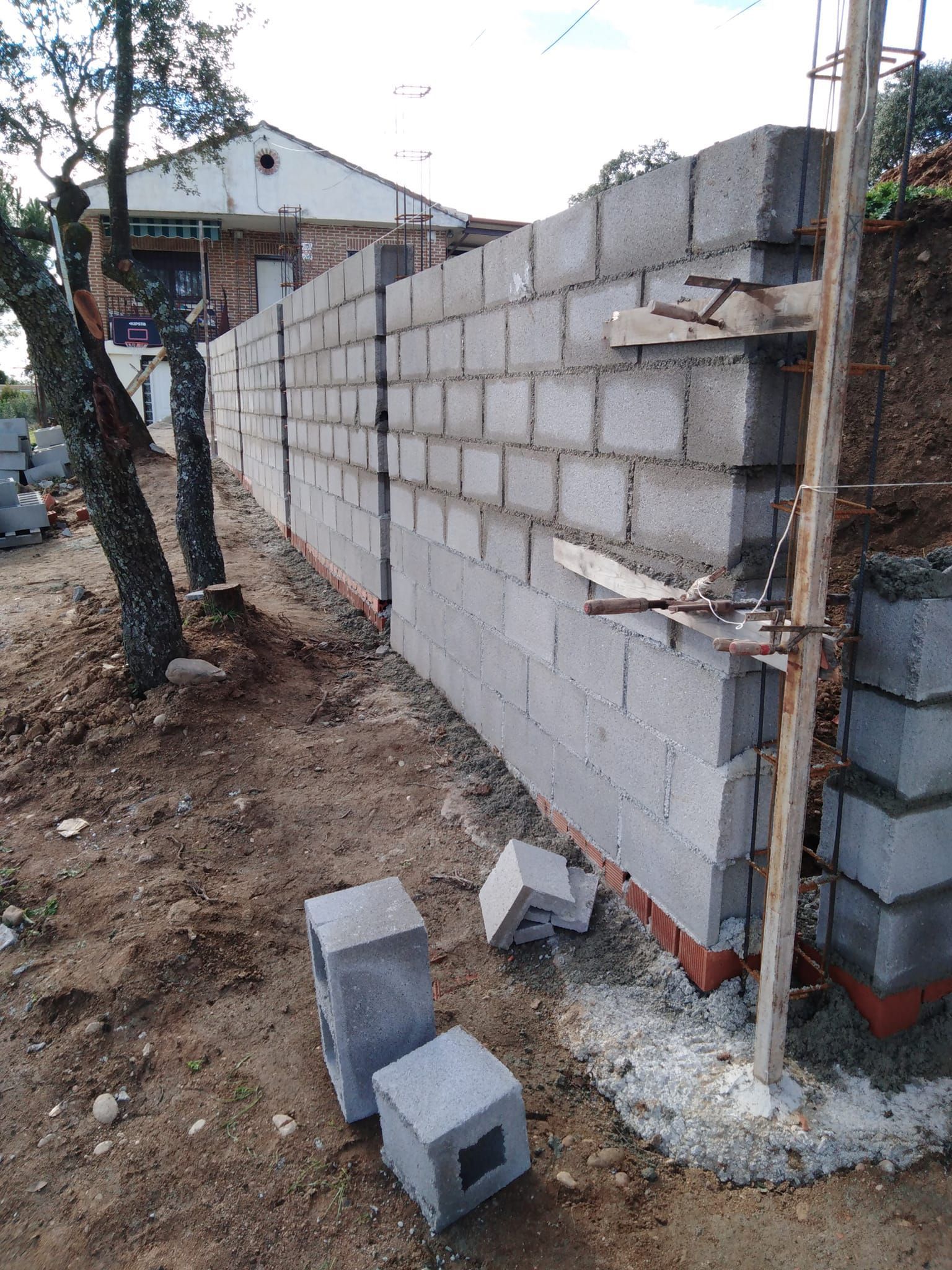Se está construyendo un muro de ladrillos en una ladera de tierra.