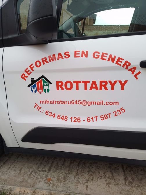 Una sala de estar con un sofá azul y una silla rosa.