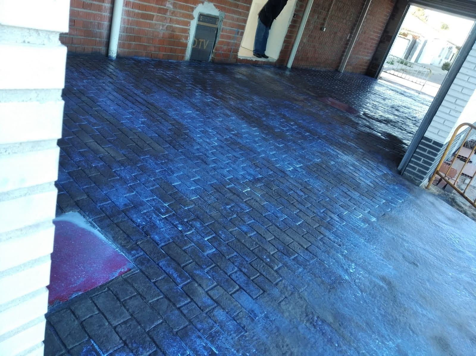Un piso de ladrillo azul con una pared de ladrillos al fondo