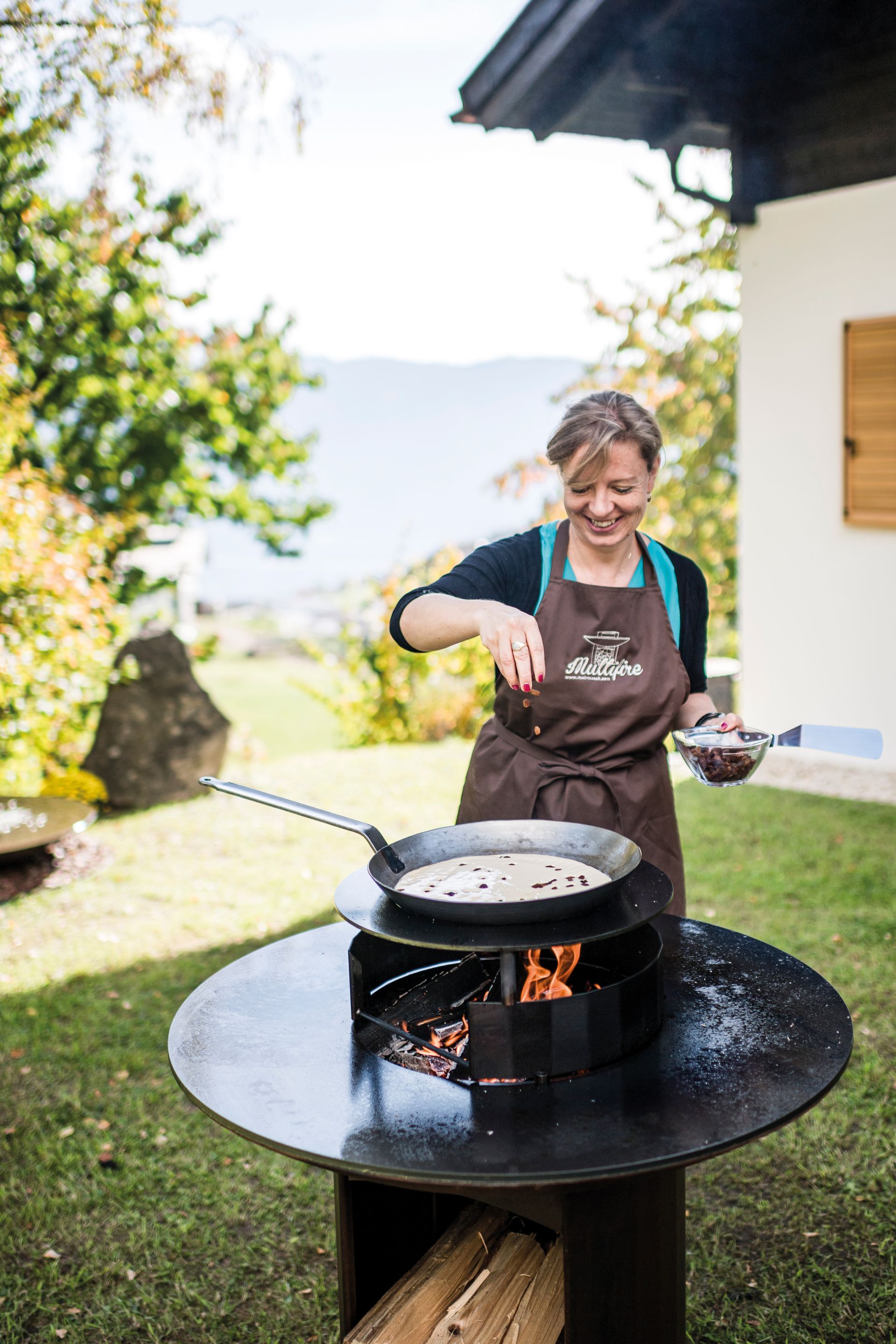 Frau kocht mit Eisenpfanne von Martin Deuflhart