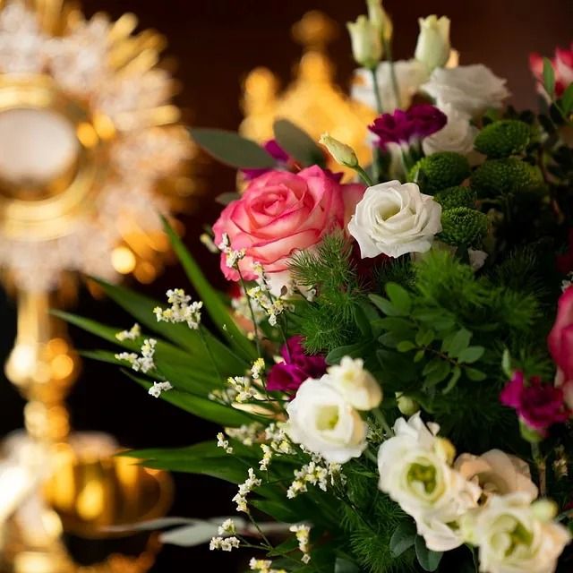 Un ramo de flores con una vela al fondo.