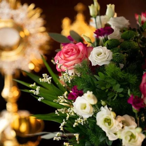 Un ramo de flores con una vela al fondo.