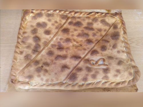 Una pizza está sobre una mesa de madera.