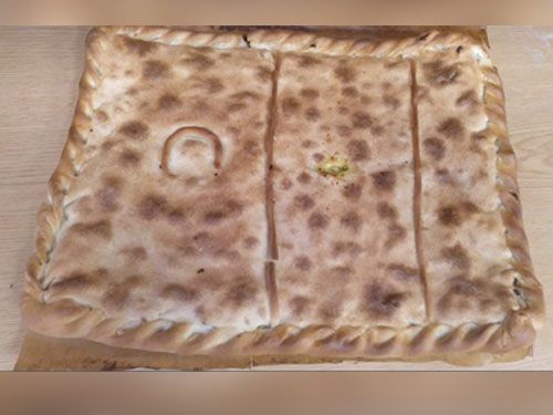 Un trozo de pan está sobre una mesa de madera.