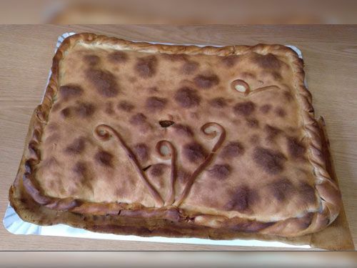 Un pastel está sobre un plato de papel sobre una mesa de madera.