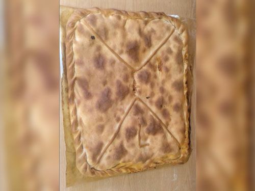 Un gran trozo de pan está sobre una mesa de madera.