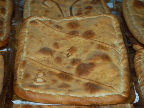 Un montón de pasteles están colocados uno encima del otro sobre una mesa.