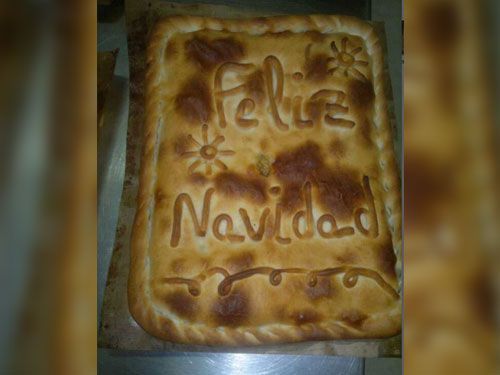 Una pizza con las palabras feliz navidad escritas en ella.