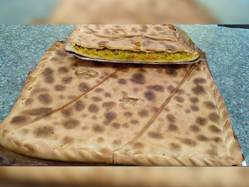 Un gran trozo de pan se encuentra encima de una mesa.