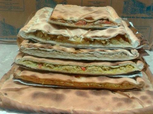 Una pila de pizzas colocadas una encima de otra sobre una mesa.