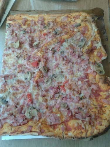 Una pizza a la que le falta un trozo está sobre una mesa.